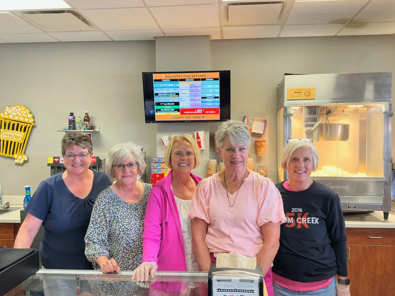 Community volunteers standing behind the theatre concession counter